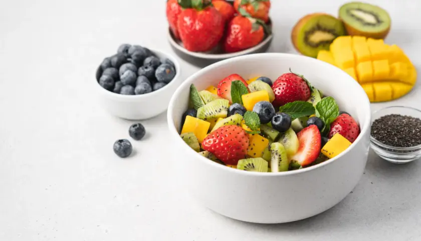 Kolorowa sałatka owocowa z truskawkami, kiwi, mango i borówkami. Idealna na zdrową przekąskę, zawiera owoce o niskim indeksie glikemicznym.